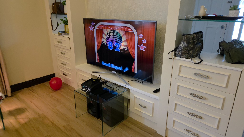 Living room karaoke TV screen displaying a score of 82 and Good Singer