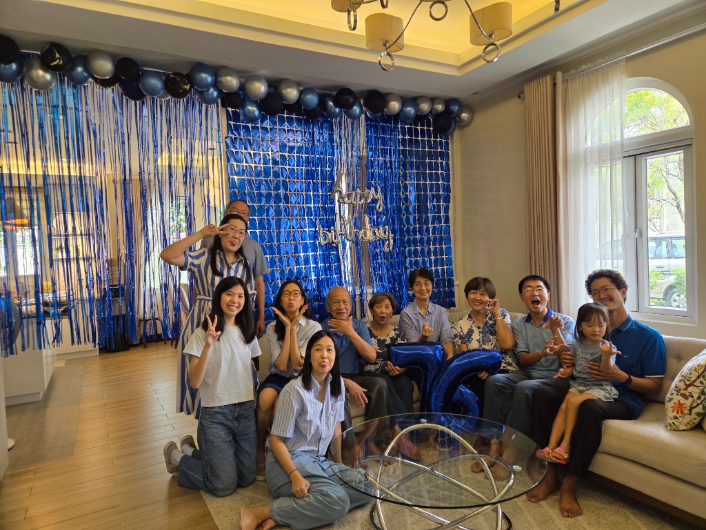 Full family group photo in front of the blue metallic balloon backdrop
