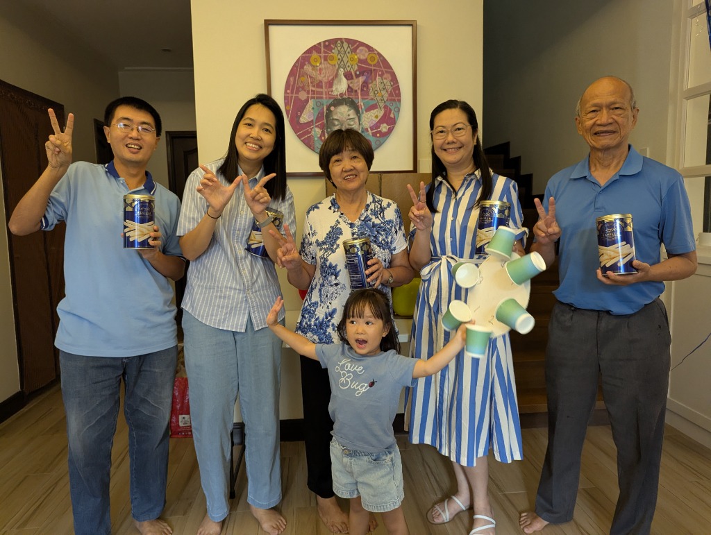 Family members celebrating with the cup spinner game and wafer stick tin prizes